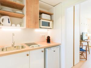 a kitchen with a sink and a microwave at Club del Sol Aparthotel in Port de Pollensa