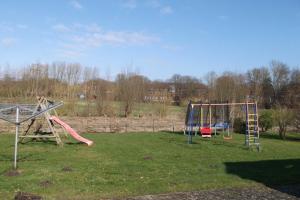 a playground with two swings and a slide at Peper Ute in Neustadt in Holstein