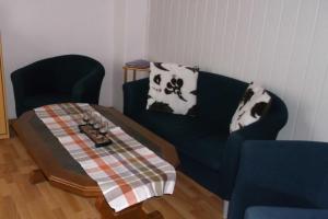 ein Wohnzimmer mit einem Sofa und einem Tisch in der Unterkunft Peper Ute in Neustadt in Holstein