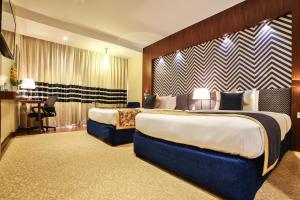 a hotel room with two beds and a desk at Ramoji Film City- Sitara Luxury Hotel in Pedda Ambarpet