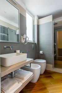 uma casa de banho com um lavatório, um WC e um espelho. em NovaNova em Nápoles
