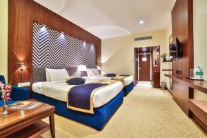 a hotel room with two beds and a tv at Ramoji Film City- Sitara Luxury Hotel in Pedda Ambarpet