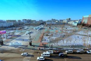 a parking lot with cars parked in a city at Hotel Zabaykalie in Chita