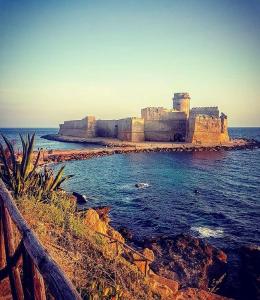 an old castle sitting on the shore of the ocean at Central Apartments in Crotone