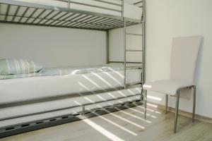 sypialnia z łóżkiem piętrowym i krzesłem w obiekcie Apartma Fani-Kobarid w mieście Podbela