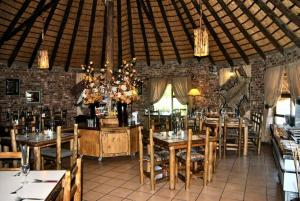 a dining room with tables and chairs in a building at Majuba Guest Lodge in Volksrust