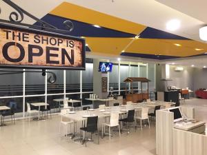 a restaurant with tables and chairs and a sign that says the shop is open at Hotel 88 Bekasi By WH in Bekasi