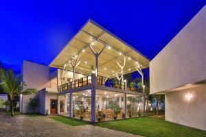 - un grand bâtiment avec balcon la nuit dans l'établissement Arugambay Roccos, à Baie d'Arugam