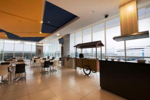 a restaurant with tables and chairs and large windows at Hotel 88 Bekasi By WH in Bekasi