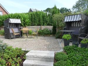 um jardim com comodidades para churrascos, uma mesa e cadeiras em Appartements am Wildpark em Malente