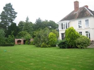a large white house with a large yard at Trelough House B&B in Wormbridge
