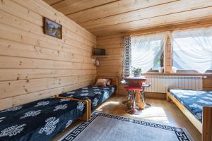 a log cabin bedroom with two beds and a table at Mazurkowy Gościniec in Zakopane +57 photos