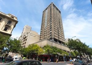 un edificio alto en una calle de la ciudad con coches en Cartwrights CNR 2 Bed Apartments en Ciudad del Cabo