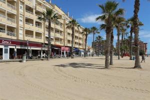 una strada con palme di fronte a un edificio di La Mata Apartment 5080 a La Mata