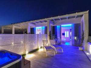a patio with two chairs and a hot tub at night at Hotel Montecarlo in Bibione