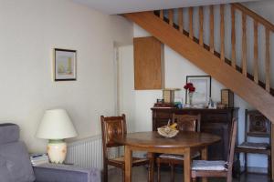 a living room with a table and a staircase at La Grande Malardiere in Saint-Georges-Buttavent