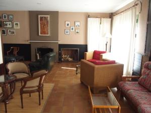 a living room with a couch and chairs and a fireplace at Hotel El Tablazo in Villalba de la Sierra