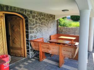 a porch with a wooden bench and a table at Holiday Home Dobrotin in Vojnik
