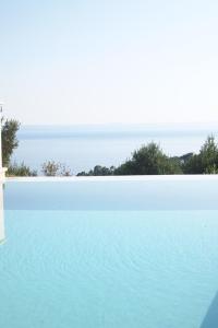 a swimming pool with the ocean in the background at Open Hus in Krvavica