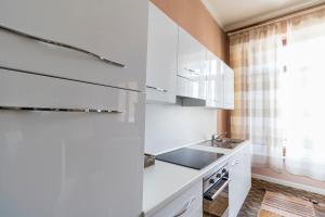 uma cozinha com armários brancos e um lavatório em Casa del Fotografo em Alba