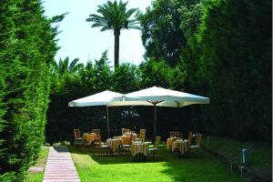 a group of tables and chairs with umbrellas at Montespina Park Hotel in Naples