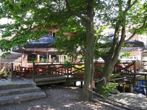 una mesa de picnic con mesas y sombrillas junto a un árbol en Apartament Wakacje i rowery gratis, en Ostróda