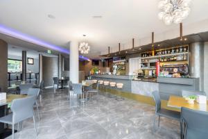 a restaurant with tables and chairs and a bar at Lake Como Golf Hotel in Como