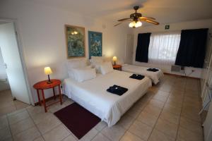 a bedroom with two beds and a ceiling fan at Clinch Self Catering in Durban