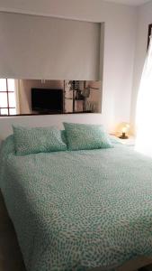 マスパロマスにあるBungalow THE EIGHTのベッドルームに緑の掛け布団付きのベッド1台