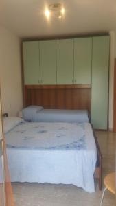 1 dormitorio con 1 cama con sábanas y armarios blancos en Casa Swami, en La Spezia