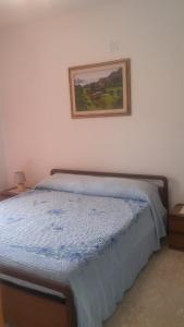 1 cama en un dormitorio con una foto en la pared en Casa Swami, en La Spezia