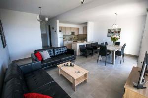 a living room with a black couch and a table at Diamond Townhouse 17 in Paphos