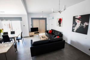 a living room with a black couch and a table at Diamond Townhouse 17 in Paphos