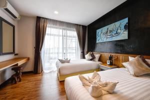 Cette chambre comprend 2 lits et une fenêtre. dans l'établissement Casa Bella Phuket, à Chalong