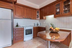 a kitchen with a table with a bowl of fruit on it at Venilia Apartments-2 in Zakynthos Town