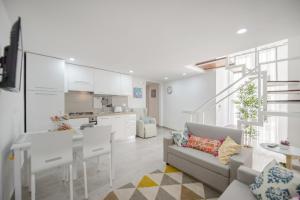 eine Küche und ein Wohnzimmer mit einem Sofa und einem Tisch in der Unterkunft MIRANDA APARTMENTS nel cuore del Vomero in Neapel