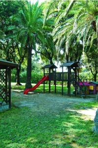 a park with a playground with palm trees and a slide at Montespina Park Hotel in Naples