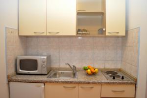 a kitchen with a sink and a microwave at Apartments Ivica in Makarska