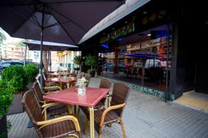 un restaurante al aire libre con mesas, sillas y sombrillas en Hotel Borgia, en Gandía