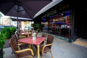 an outdoor restaurant with tables and chairs with umbrellas at Hotel Borgia in Gandía