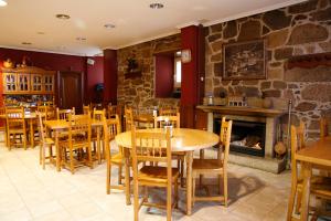 ein Restaurant mit Holztischen und -stühlen und einem Kamin in der Unterkunft Hotel Pousada Vicente Risco in Castro Caldelas