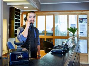 a man talking on a telephone in an office at Strand Fjordmotel in Ulvik