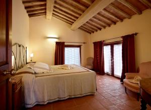 a bedroom with a large bed and two windows at B&B Borgo Petrognano - Residenza d'Epoca in Barberino di Val dʼElsa