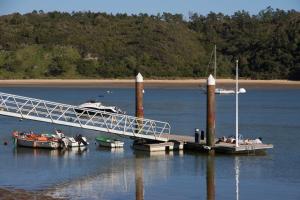 a group of boats docked at a dock in the water at PIER HOUSES by Nature Bliss in Vila Nova de Milfontes