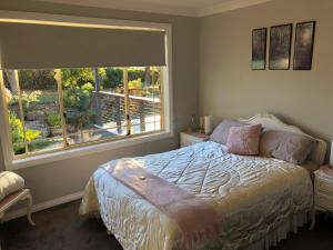 a bedroom with a bed and a large window at Rocky Rest in Orange