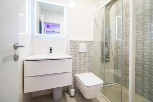 a white bathroom with a toilet and a shower at Apartman M.E.P. in Split +10 photos
