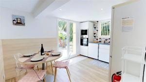 een keuken en eetkamer met een tafel en stoelen bij L'EFFERVESCENT in Saint-Péray