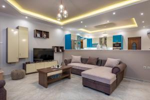 a living room with a couch and a tv at Aquarella Luxury Apartment in Argasi