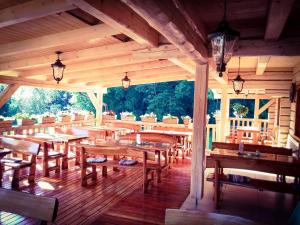 un restaurante de madera con mesas y bancos de madera en Penzión Mlynárka en Rajecké Teplice
