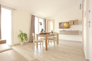 a living room with a wooden table and chairs at Alma di Alghero Apartments in Alghero